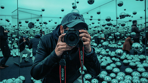 A man taking a photo in a mirror maze